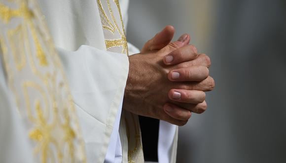Un sacerdote tiene las manos unidas durante una misa para conmemorar la Asunción de la Virgen María en Lourdes, sur de Francia, el 15 de agosto de 2022. (Foto referencial: Valentine CHAPUIS / AFP)