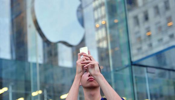 Un hombre usa un iPhone para hacer un video fuera de la Apple Store en la Quinta Avenida el 20 de septiembre de 2013 en Nueva York (Foto: Stan Honda / AFP)