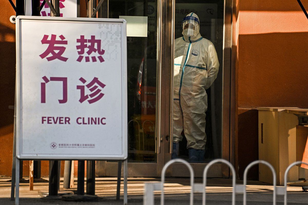 A security staff in protective gear stands guard at the entrance of a fever clinic in Beijing on December 28, 2022. (Photo by Noel CELIS / AFP)