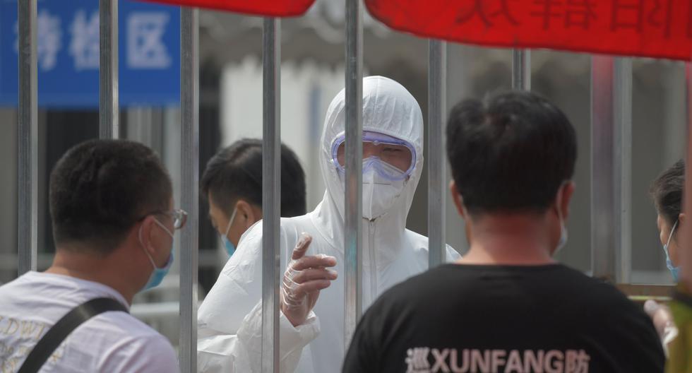 Un policía usa un traje de protección en un centro de pruebas de coronavirus COVID-19 en Beijing, China. . (Foto por GREG BAKER / AFP).