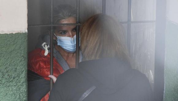 Tras las rejas, la expresidenta interina de Bolivia, Jeanine Áñez, habla con una mujer no identificada en la cárcel de una comisaría en La Paz, el 13 de marzo de 2021. (AP Foto/Juan Karita).