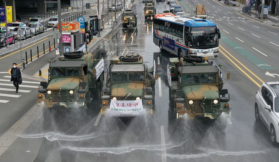 Los vehículos militares rocían desinfectante como parte de las medidas preventivas contra la propagación del coronavirus COVID-19, en una carretera cerca de la estación de ferrocarril de Dongdaegu en Daegu, Corea del Sur. (Foto: AFP)