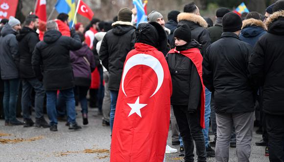 Un participante se para con una bandera de Turquía mientras la organización pro-turca Unión de Demócratas Turcos Europeos (UETD) se manifiesta en apoyo de Turquía y el presidente Recep Tayyip Erdogan frente a la Embajada de Turquía en Estocolmo, Suecia, el 21 de enero de 2023. (Foto: Fredrik SANDBERG / Agencia de noticias TT / AFP)