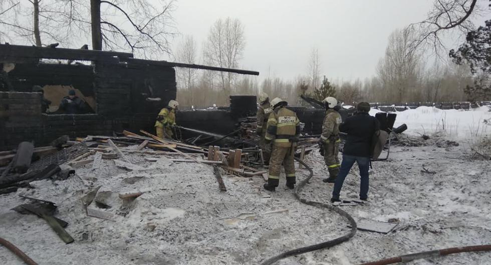 Esta fotografía del Ministerio de Emergencias de Rusia muestra a los bomberos que trabajan en el lugar del incendio que se produjo en una choza de madera. (AFP)