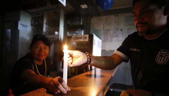Un hombre enciende una vela en un bar, durante un apagón de energía eléctrica, en Quito, Ecuador, el 28 de octubre de 2023. (Foto de Santiago Fernández / EFE)