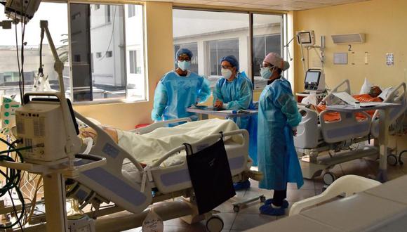 Los trabajadores de la salud revisan las placas de rayos X de un paciente con COVID-19 en la sala de cuidados intensivos del Hospital Pablo Arturo Suárez, en Quito. (Foto: Rodrigo BUENDIA / AFP)