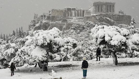 La gente camina cerca de la colina Pnyx cubierta de nieve durante las fuertes nevadas sobre Atenas, Grecia, el 16 de febrero de 2021. (Foto de LOUISA GOULIAMAKI / AFP).