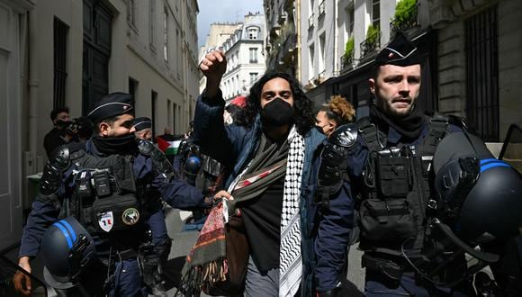 Un manifestante es escoltado por gendarmes franceses durante la evacuación de una sentada a favor de Gaza en el vestíbulo de entrada del Instituto de Estudios Políticos (Sciences Po Paris) en París el 3 de mayo de 2024. (Foto de Miguel MEDINA/AFP)