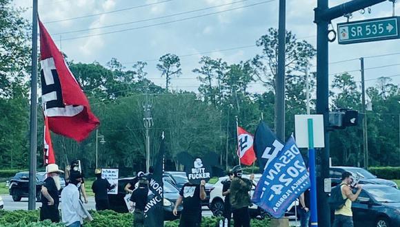 Simpatizantes del gobernador de Florida y candidato en las primarias republicanas, Ron DeSantis se manifiestaron el sábado con carteles de apoyo a su candidatura y banderas con la esvástica en la entrada del parque temáticoWalt Disney World. (Foto: Twitter)