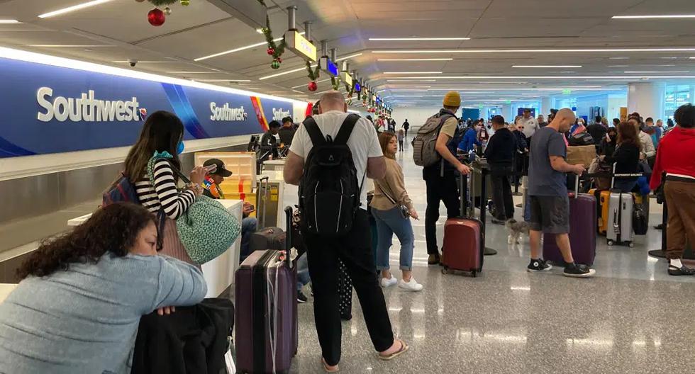 Los viajeros esperan en un mostrador de equipaje de Southwest Airlines para recuperar sus maletas después de vuelos cancelados en el Aeropuerto Internacional de Los Ángeles, el lunes 26 de diciembre de 2022. (Foto AP/Eugene García).