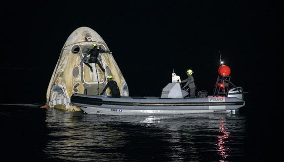Esta imagen, de cortesía de la NASA, muestra a los equipos de apoyo que trabajan en torno a la nave espacial SpaceX Crew Dragon Resilience poco después de que aterrizara con los astronautas Mike Hopkins, Shannon Walker, Victor Glover y Soichi Noguchi. (Bill INGALLS / NASA / AFP)