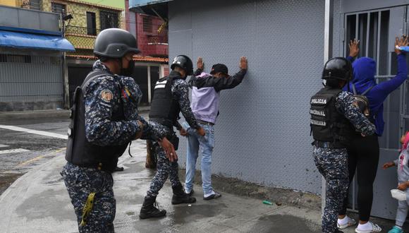 La Policía Nacional Bolivariana de Venezuela cachea a personas durante enfrentamientos con presuntos integrantes de una banda criminal en los alrededores del barrio Cota 905, en Caracas, el 9 de julio de 2021. (Yuri CORTEZ / AFP).