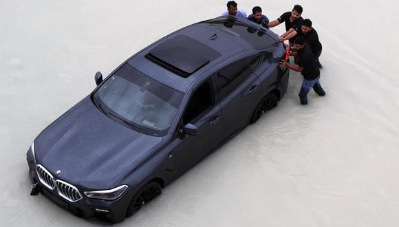 La gente empuja un coche durante una fuerte lluvia en Dubái, Emiratos Árabes Unidos, 16 de abril de 2024. (EFE/EPA/ALI HAIDER).