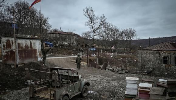 Un soldado armenio hace guardia junto a una carretera frente a una casa en el pueblo de Shurnukh el 4 de marzo de 2021. (Foto de ARIS MESSINIS / AFP)