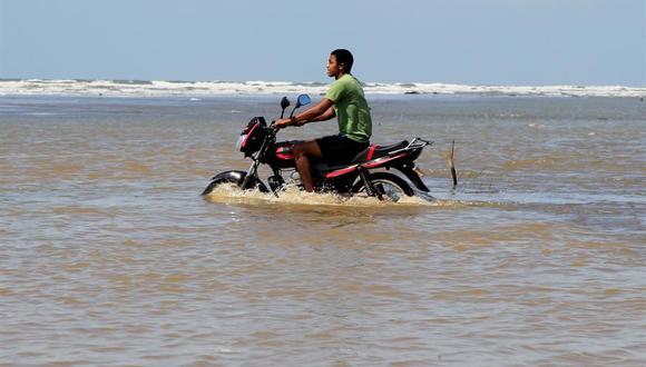 Un hombre transita en una moto por las inundaciones en el sector Marlinda y la boquilla, en Cartagena (Colombia). El paso del huracán Iota frente a las costas de Cartagena de Indias dejó marejadas que han inundado algunos sectores de la ciudad. (EFE/ RICARDO MALDONADO ROZO).