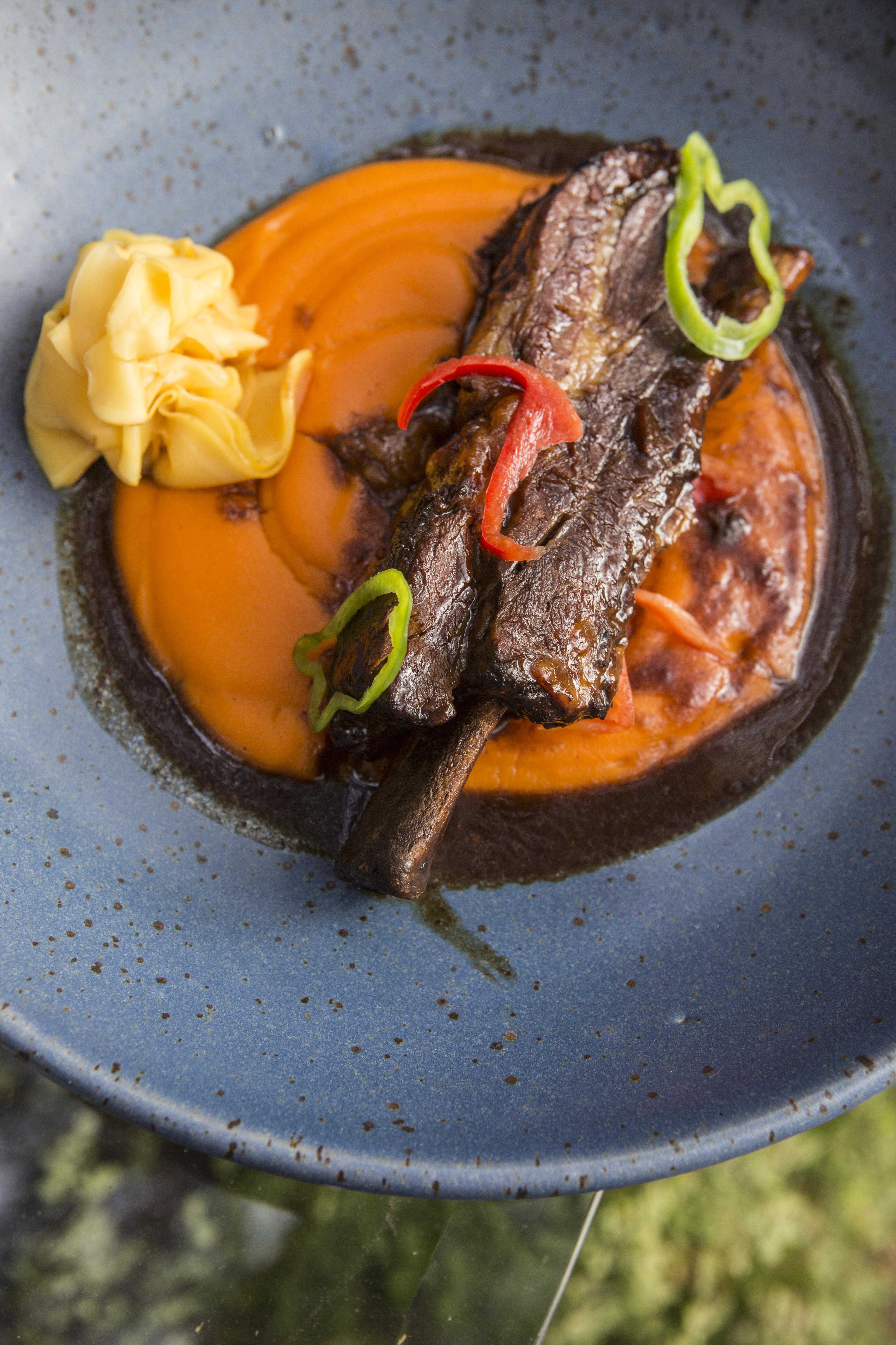 Jugoso asado de tira braseado. Viene con puré de papas y pimientos piquillo, y ollucos encurtidos.