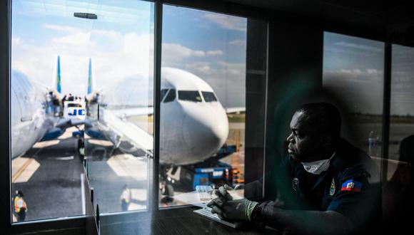 Imagen referencial. Un empleado del departamento de salud de Haití espera a los viajeros entrantes en el Aeropuerto Internacional de Puerto Príncipe, el 4 de febrero de 2020. (CHANDAN KHANNA / AFP).