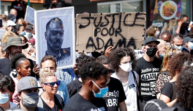 Personas con mascarillas asisten a una marcha en memoria de Adama Traoré, un afrodescendiente de 24 años que murió en Francia en una operación policial en 2016. Imagen en Beaumont-sur-Oise, cerca de París, Francia. (REUTERS/Gonzalo Fuentes).