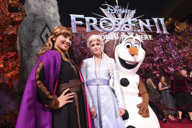 Millie Aukee, vestida como Anna, y Anne Goodman, vestida como Elsa, posan junto a Olaf en la premiere de "Frozen 2" (Foto: AP)