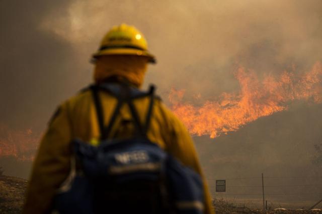 Los bomberos trabajan para controlar el incendio de Silverado que arde cerca de Irvine en el condado de Orange, al sur de Los Ángeles, California. (EFE/ETIENNE LAURENT).