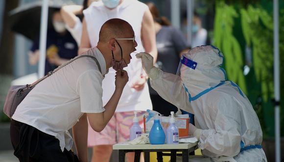 Un trabajador de la salud toma una muestra para la prueba del coronavirus covid-19 en Beijing, China, el 23 de mayo de 2022. (Noel Celis / AFP).