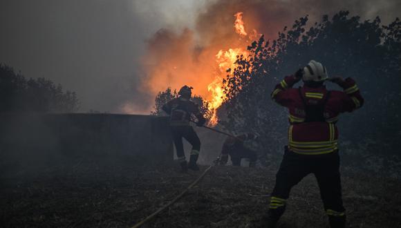 Los bomberos intentan extinguir un incendio forestal cuando se acerca al pueblo de Zambujeiro en Cascais el 25 de julio de 2023. (Foto de Patricia DE MELO MOREIRA / AFP)