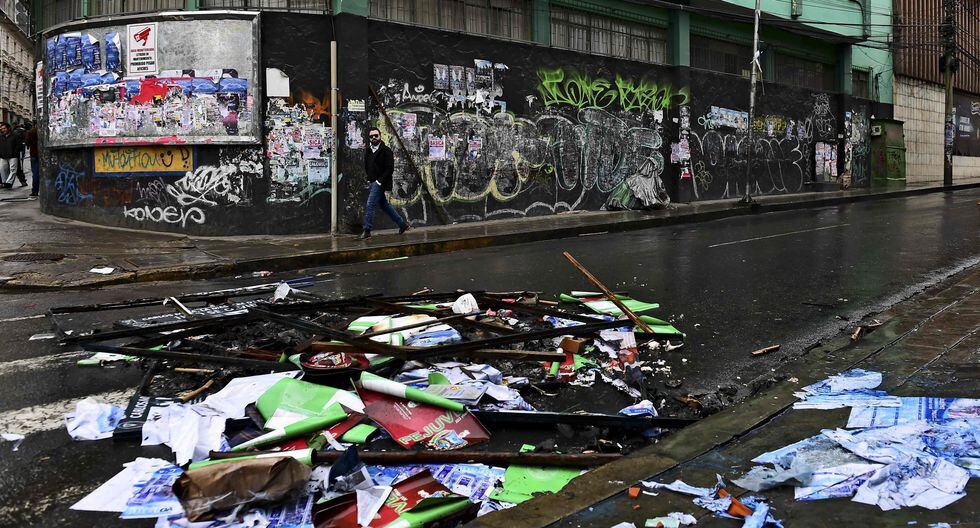 Un hombre camina por las calles vacías, llenas de destrozos ante las aparentes represalias por la renuncia de Morales. (Foto: AFP) Un hombre camina por las calles vacías, llenas de destrozos ante las aparentes represalias por la renuncia de Morales. (Foto: AFP)