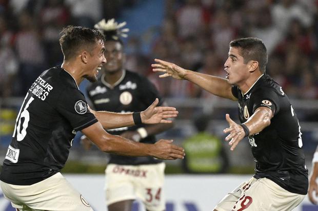 Universitario's defender Aldo Corzo (R) celebrates with teammate Martin Perez Guedes after scoring a goal during the Copa Libertadores group stage first leg football match between Colombia's Junior and Peru's Universitario at the Metropolitano Roberto Melendez Stadium in Barranquilla, Colombia, on April 9, 2024. (Photo by Luis ACOSTA / AFP)