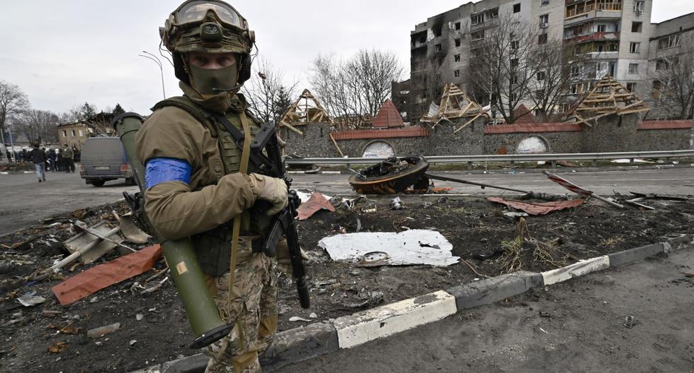 Un militar ucraniano hace guardia en una calle al lado de un edificio dañado en la ciudad de Borodianka, al noroeste de Kiev, el 6 de abril de 2022. (Genya SAVILOV / AFP).