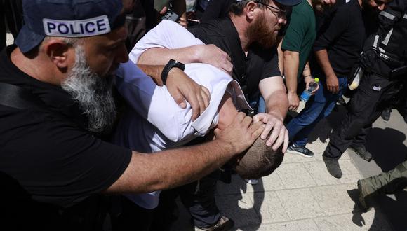 La policía israelí detiene a un hombre en el lugar de un ataque con embestida en Jerusalén, el 22 de abril de 2024. (Foto de Menahem Kahana / AFP)
