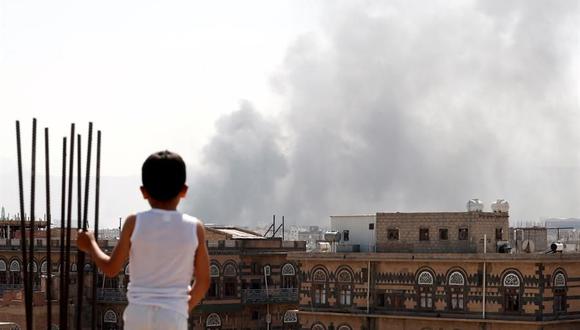Un niño yemení observa el humo que se eleva sobre un vecindario luego de los ataques aéreos liderados por Arabia Saudita contra posiciones en Saná, Yemen, el 7 de marzo de 2021. (EFE / EPA / YAHYA ARHAB).