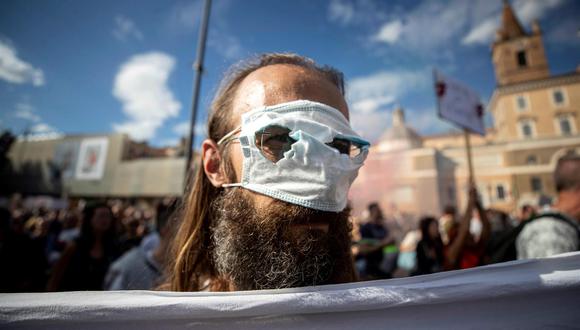 Un manifestante usa una mascarilla sanitaria a modo de antifaz durante una protesta en Roma, Italia, encabezada por el partido de extrema derecha de Forza Nuova. (EFE/ Massimo Percossi).