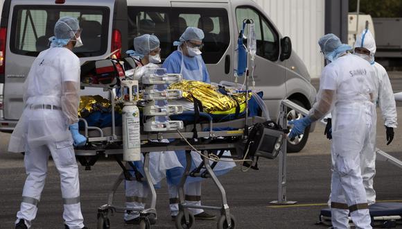 Personal médico del hospital carga pacientes con la enfermedad covid-19 en un avión para ser evacuados en el aeropuerto de Avignon, Francia. (EFE/EPA/GUILLAUME HORCAJUELO)