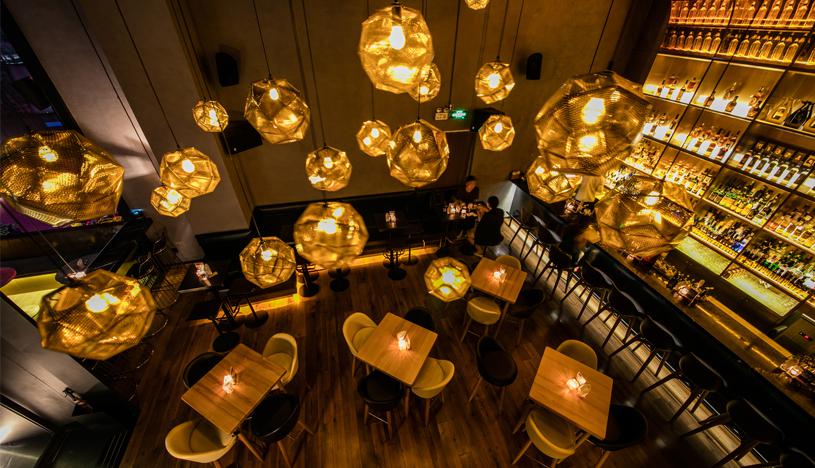 Las luces doradas colgantes están repartidas en el techo del bar, las cuales hacen que el espacio luzca acogedor y luminoso. Un diseño muy en vanguardia. (Foto: Tony Chen/ Hejidesign Shenzhen)