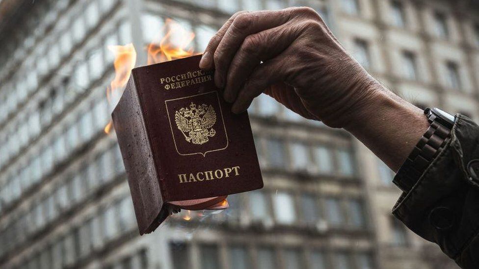 A man burns a Russian passport in protest at the war.