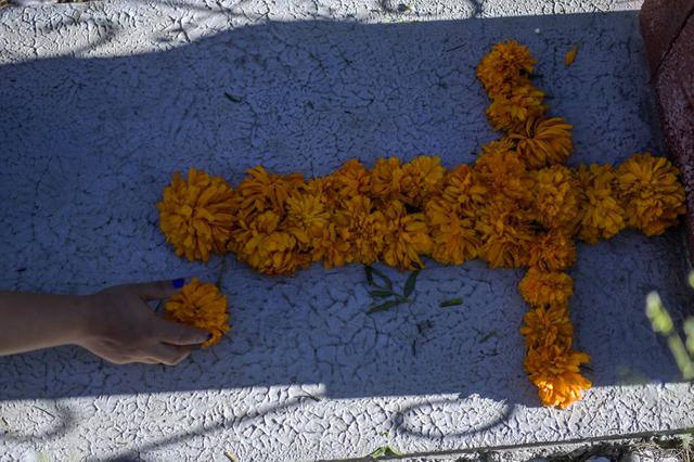 Una tumba es decorada con una cruz hecha con flores en el Panteón La Magdalena, en San Pedro Cholula, estado de Puebla, México. (PEDRO PARDO / AFP)