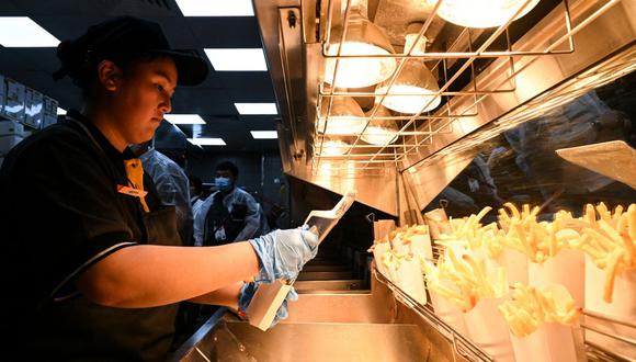 Trabajadores de McDonald's sirviendo papas fritas. (Foto referencial: Kirill KUDRYAVTSEV / AFP)