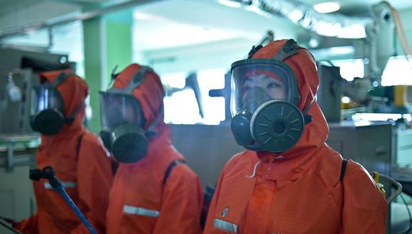 Funcionarios de salud desinfectan el lugar de trabajo en la Fábrica de Cosméticos de Pyongyang, en Corea del Norte, el 16 de junio de 2022. (KIM Won Jin / AFP).