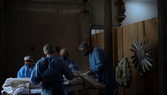 Coronavirus: Enfermeros acomodan el cuerpo de un fallecido en una morgue improvisada en la iglesia del hospital Centenario, el 23 de marzo de 2021, en São Leopoldo, Rio Grande do Sul, Brasil. (EFE/ Daniel Marenco).