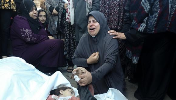 La madre de los gemelos de ocho años Ahmed y Jihan Nasser, que murieron durante el bombardeo israelí, llora sobre sus cuerpos en el hospital Al-Aqsa en Deir al-Balah, en el centro de la Franja de Gaza, el 29 de diciembre de 2023, en medio de batallas en curso entre Israel y el grupo militante palestino Hamás. (Foto de AFP)