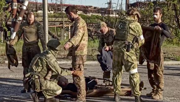 Soldados rusos cacheando a los militares ucranianos mientras son evacuados de la planta siderúrgica sitiada de Azovstal en Mariupol, Ucrania, el 17 de mayo de 2022. (EFE).