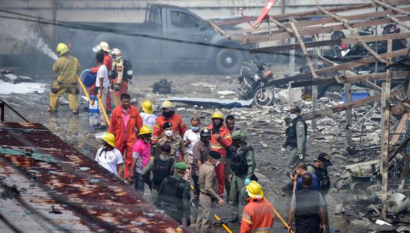 Oficiales de policía y trabajadores de rescate inspeccionan los daños después de que un coche bomba explotara frente a un alojamiento policial en la ciudad de Narathiwat, al sur de Tailandia, el 22 de noviembre de 2022. (Foto de Madaree TOHLALA / AFP)