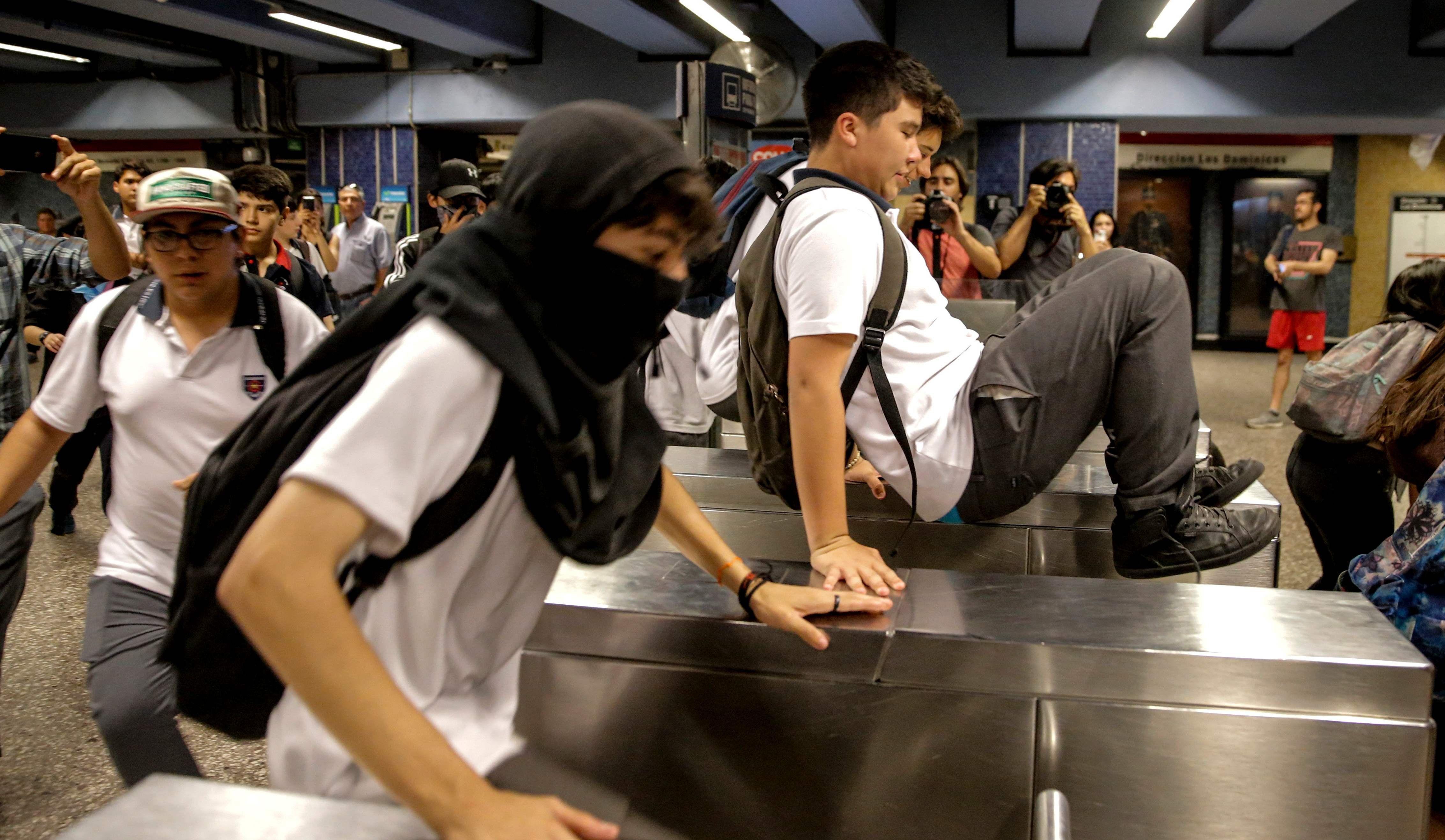 Estudiantes chilenos protagonizan nuevas evasiones en el metro de Santiago de Chile. (AFP / JAVIER TORRES).