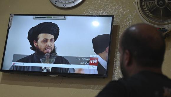 En esta imagen tomada el 3 de setiembre de 2021, un hombre en un restaurante mira una transmisión de televisión en vivo del canal Tolo News que muestra a un erudito religioso hablando, en Kabul. (WAKIL KOHSAR / AFP).