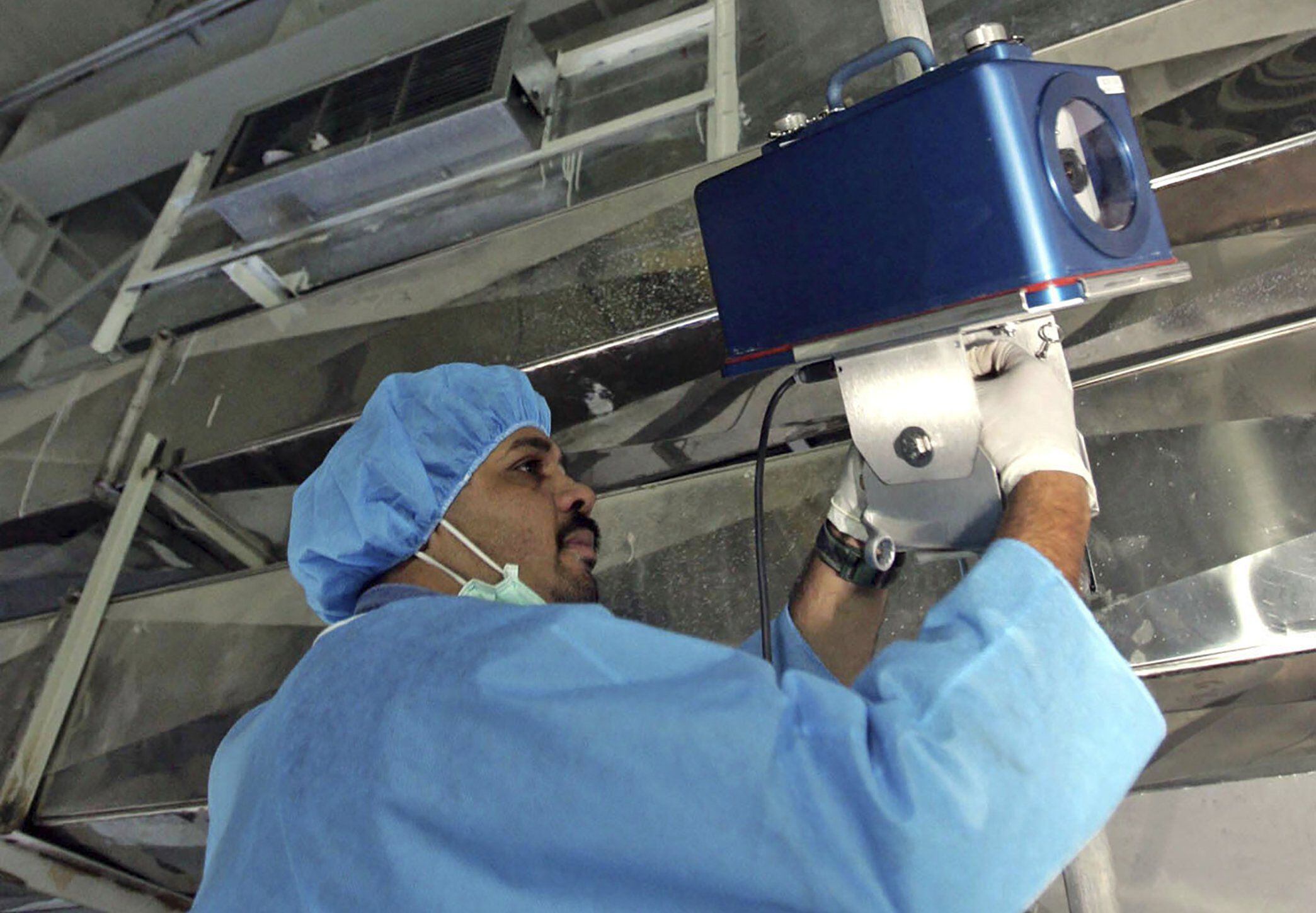 An inspector from the International Atomic Energy Agency sets up surveillance equipment at Iran's Uranium Conversion Facility outside the city of Isfahan, Iran, in August 2005. (Photo: AP)