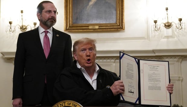 Donald Trump promulgó una partida de gastos por US$ 8.300 millones para combatir el brote de coronavirus. Al costado del mandatario aparece Alex Azar, secretario del Departamento de Salud y Servicios Humanos. (AP).