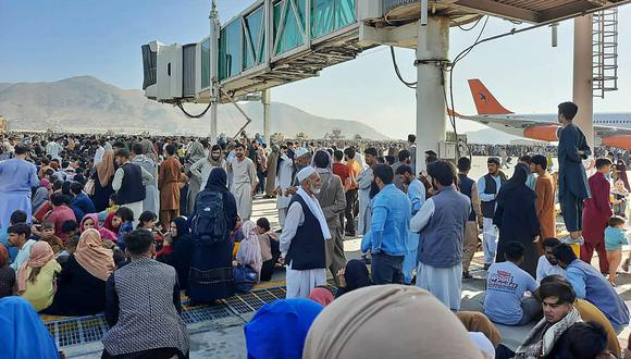 Los afganos se agolpan en la pista del aeropuerto de Kabul el 16 de agosto de 2021 para huir de los talibanes. (AFP).