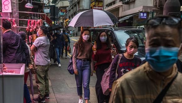La gente camina por una calle de Hong Kong el 28 de marzo de 2022. (Foto de DALE DE LA REY / AFP)