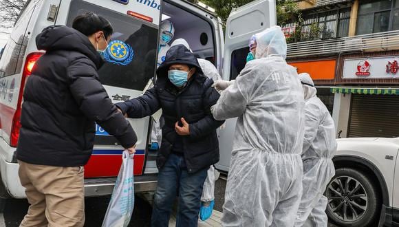 La imagen muestra a una persona sospechosa de portar el coronavirus siendo trasladada por trabajadores de salud en China. (Foto: AFP)