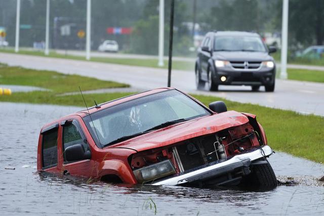 Un vehículo abandonado está sumergido en una zanja junto a una carretera mientras las bandas exteriores del huracán Ida llegan el domingo 29 de agosto de 2021 a Bay Saint Louis, Mississippi. (Foto AP / Steve Helber).